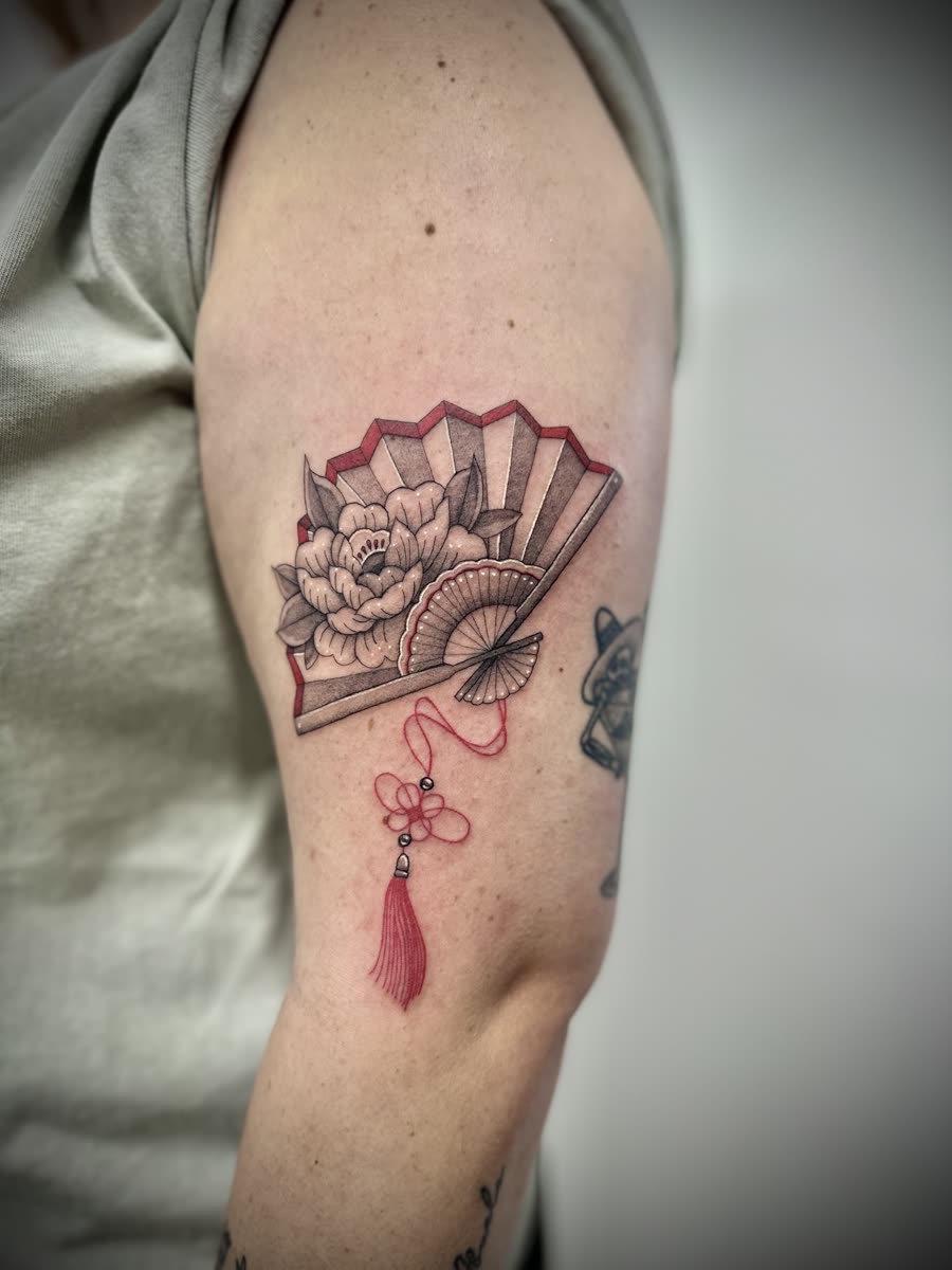 Beautiful fan tattoo with red colour work